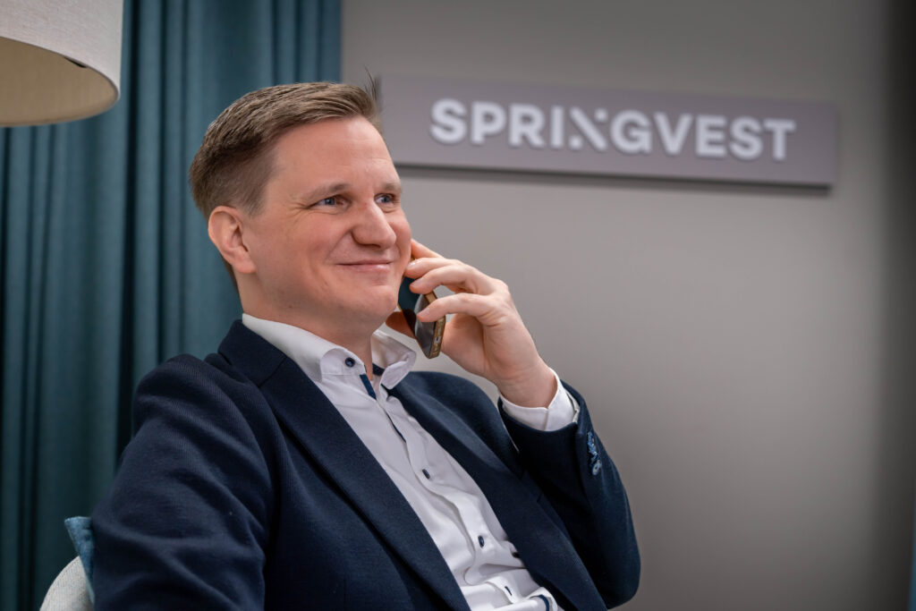 Iloinen Springvestin asiantuntija puhelimessa